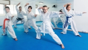 Teenagers trying a new moves with master during karate class