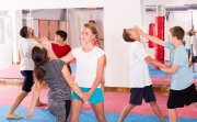 Mixed age group at self protection workout, training attack movements in pairs